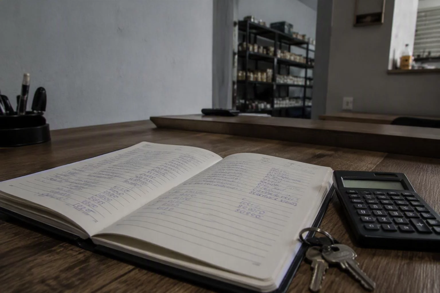 Caderno de fechamento diário aberto com os totais escritos à mão